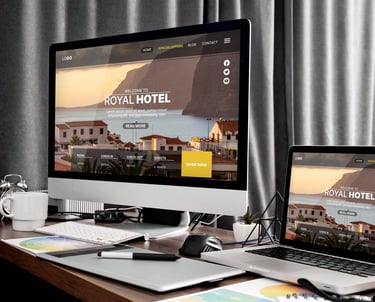 Responsive hotel website design displayed on a desktop monitor and laptop on a creative office desk.