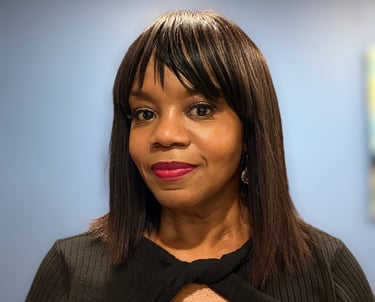 Professional portrait of Robyn smiling with dark hair and bangs wearing a black top.