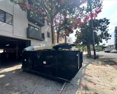 a dumpster sitting on the sidewalk next to a building