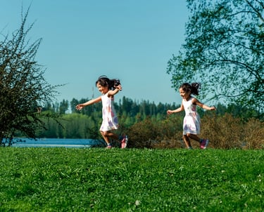 two young girls playing in grass field