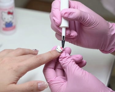 Close-up of hands receiving gel nail application in a goth salon setting.