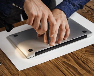 Técnico utilizando un destornillador para realizar una reparación de laptop y mantenimiento