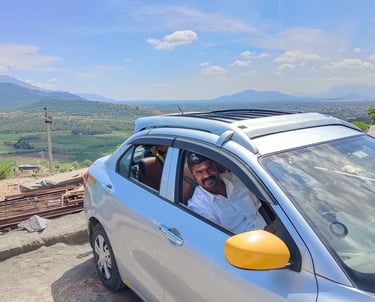South India Drop Taxi service car traveling through a scenic mountain route"