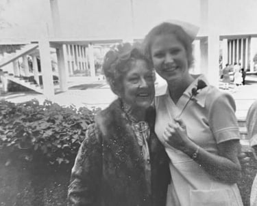 Vintage black and white photo of a smiling young nurse in uniform posing with an older woman.
