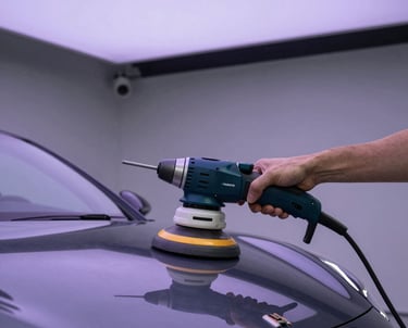 A person using a dual action orbital car polisher on a dark grey luxury vehicle hood for paint correction.