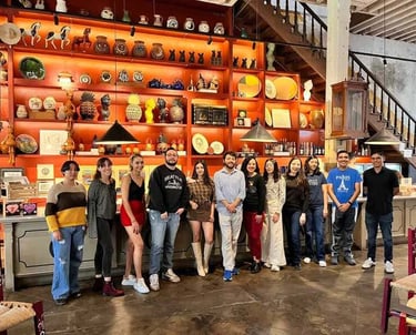 Grupo de alumnos posando en un fondo con piezas de cerámica.