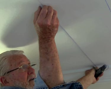 Homem instalando placas de isopor no forro