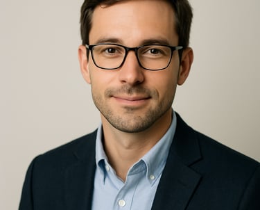 A professional headshot of a male in business casual attire, looking approachable and intelligent. Clean lighting, minimalist off white background. North American / International.