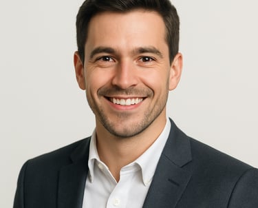 A professional headshot of a smiling male professional in a modern blazer, looking directly at the camera with confidence. Bright, clean studio lighting with an off white background. North American / International style.