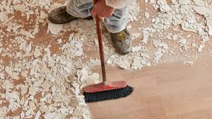 a man is cleaning a floor with a broom
