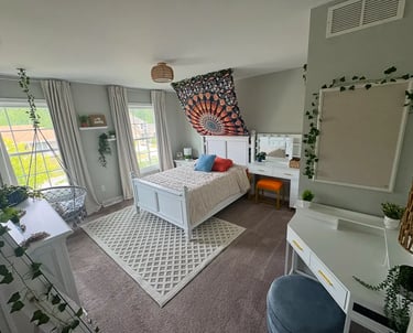 organized bedroom with decorations hanging from ceiling.