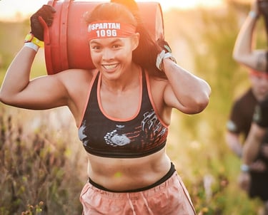 Janice McDonald carrying a heavy bucket during a Spartan Race obstacle course in Boca Raton.