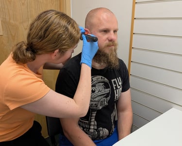 pharmacist prescriber using otoscope to perform ear examination pharmacy first plus consultation