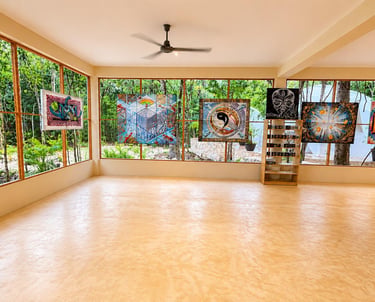 A spacious multi-purpose space, with large windows, thoughtful artwork decorating the place, overloo