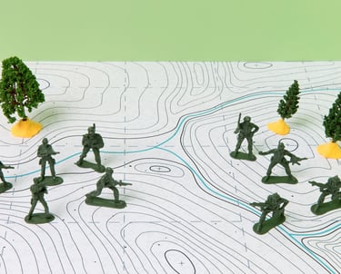Group of plastic soldiers arranged on a topographic map, representing military strategy