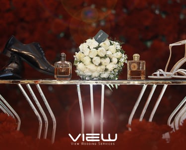 Wedding accessories including bridal shoes, groom's dress shoes, perfume, and a white rose bouquet.