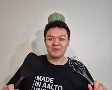 a man with a pumpkin on his head and a whisk and spatula in each of his hands