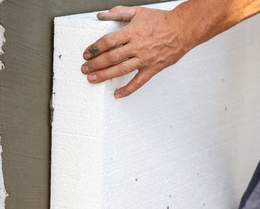 homem colando placa de isopor na parede para fazer isolamento térmico