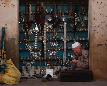 Moroccan artisan working in a traditional shop with handmade jewelry and crafts