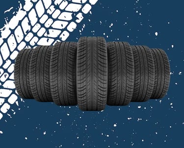 Seis neumáticos de coche nuevos con banda de rodadura visible, dispuestos en fila sobre un fondo azul oscuro con salpicaduras