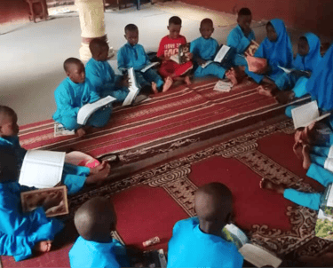a group of children sitting on a rug in a room