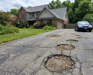 Driveway in North Olmstead with several potholes.