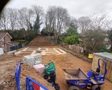 Concrete foundations for a new home construction project with a blue dumper truck and building supplies.