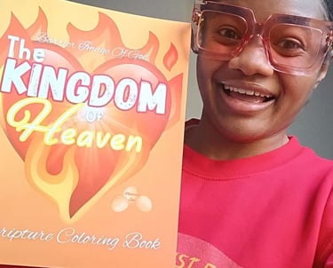 A smiling woman holding The Kingdom of Heaven scripture coloring book while wearing red glasses.