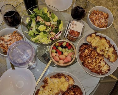 a table with plates of food and a bottle of wine