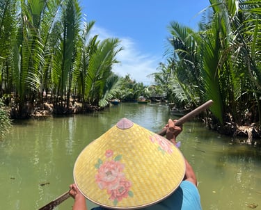 Homme vietnamien avec chapeau pointu sur un petit bateau