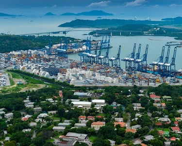 Aerial view of the Panama Canal shipping port with industrial cranes and cargo containers.