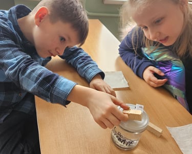 vaikai bendradarbiaudami klijuoja eksperimento detales