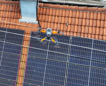 An industrial drone performs an automated thermal inspection of residential solar panels on a tile roof.