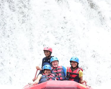 Smiling group wearing helmets and life jackets during a whitewater rafting adventure on a river.