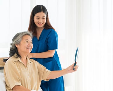 Female caregiver helping a female patient with her hair