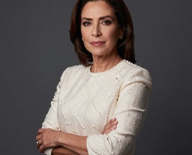 A professional portrait of a Latin American woman in her 40s, looking confident as a lead producer, dressed in professional pearl-colored clothing against a clean dark slate grey background.