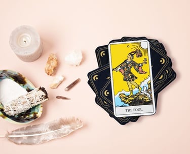 The Fool tarot card on a stack with crystals used in beginner tarot lesson