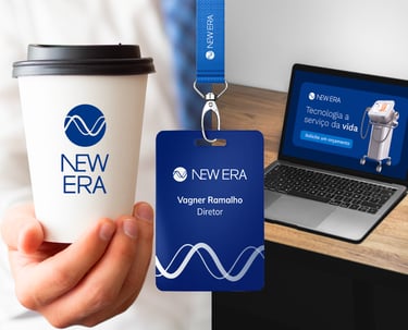 A imagem mostra um copo, um crachá e um laptop com a identidade visual New Era