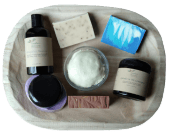 a grouping of skincare products on a wooden tray