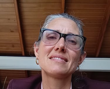 a woman in a suit and glasses sitting on a chair