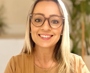 mulher loira de óculos e com um colar dourado sorrindo