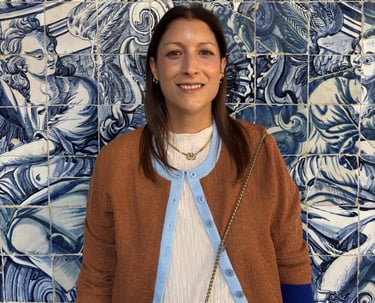 a woman standing in front of a blue tile wall