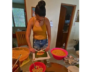 a woman making puerto rican pasteles