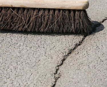Sweeping asphalt in preparation for crack repair