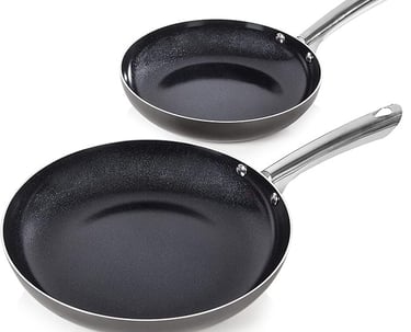 two pans with a black pan and a white background