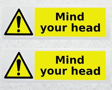 two signs with a warning sign that says mind your head
