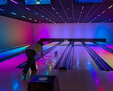 Bowling ball rolling down lane during a friendly family match.