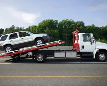 a tow truck with a junk car being towed for cash