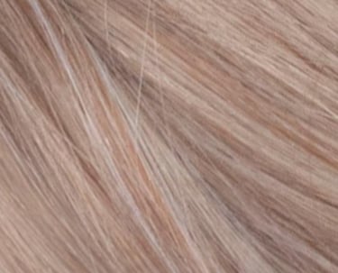 Gros plan de la texture de rallonges de cheveux blond fraise avec des mèches cendrées claires.