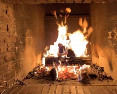 ein Holzfeuer lodert im offenen Kamin